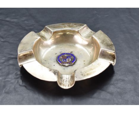 A George V silver and enamel ashtray, of dished circular form with five moulded 'rests' and central enamelled 'Nelson Gold Cl