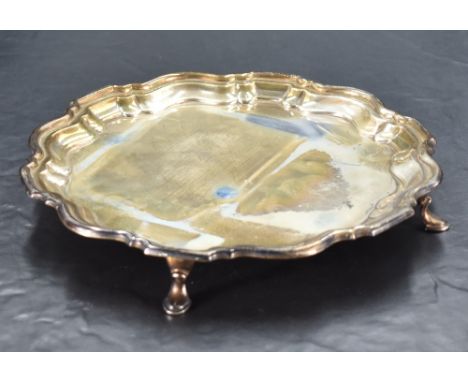 A George V silver salver of circular form with Chippendale design moulded rim, raised on three hoof feet, marks for Birmingha