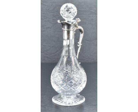 A Queen Elizabeth II silver mounted cut-crystal claret jug, having a star-cut spherical stopper over the flared silver mount 