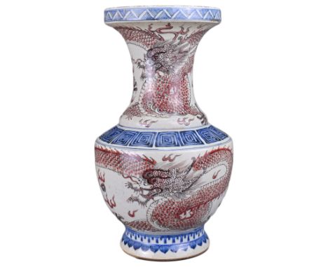 A CHINESE UNDERGLAZE BLUE AND RED DRAGON VASE. The vase body and neck decorated with dragons chasing flaming pearls with key 
