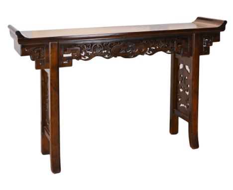 A CHINESE ELM ALTAR TABLE, 20TH CENTURY. The rectangular top with typical scroll-form ends, a pierced and carved floral friez