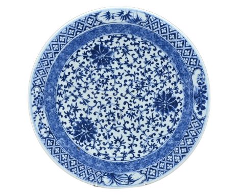 A LARGE CHINESE BLUE AND WHITE PORCELAIN CHARGER, 19TH CENTURY. Decorated with lotus scrolls. Six-character mark of Kangxi to