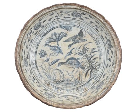 A LARGE VIETNAMESE BLUE AND WHITE CERAMIC DISH, 16TH CENTURY. The deep heavily-potted bracket lobed dish decorated in undergl