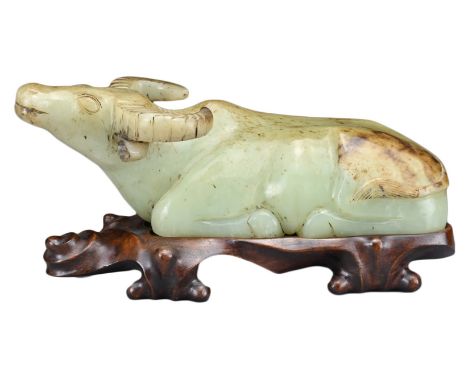 A CHINESE JADE CARVING OF RECUMBENT WATER BUFFALO. The celadon and russet jade carving of water buffalo with legs tucked unde