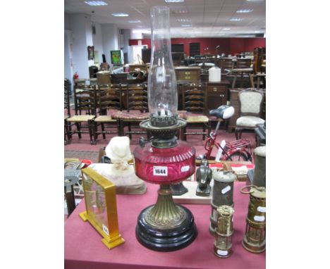 An Early XX Century Oil Lamp, with circular black glaze terracotta base and sixteen sided cranberry glass well.