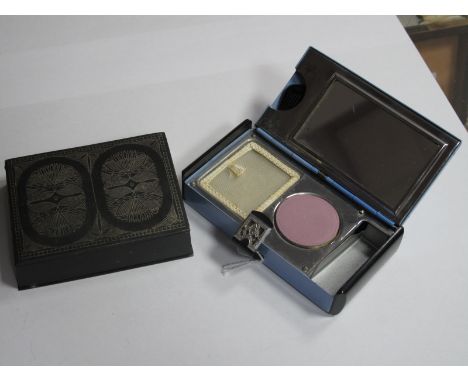 An Art Deco Compact, with fitted interior for lipstick, powder, blush and comb; together with a Niello style rectangular ciga