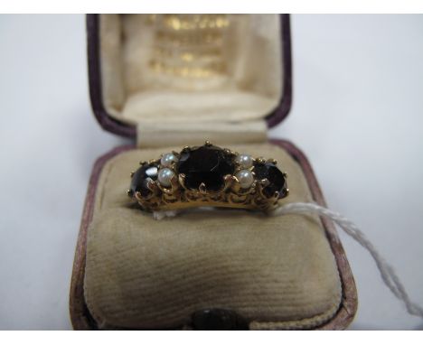 A 9ct Gold and Garnet Dress Ring set with Seed Pearls, comprising three graduated garnet stones claw set between pearl accent