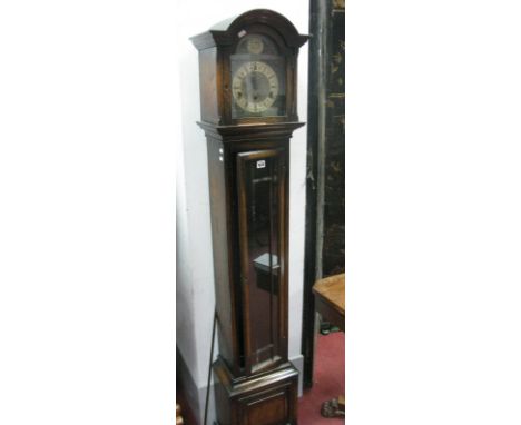 A 1920's Oak Musical Grandmother Clock, with a arched hood, glazed astragal door, panelled base, on bracket feet, with arched