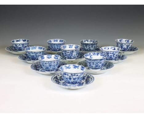 China, a set of ten blue and white porcelain cups and twelve saucers, Kangxi period (1662-1722), each decorated with a flower