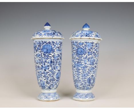 China, a pair of blue and white porcelain beaker vases and covers, Kangxi period (1662-1722), each moulded with ribbed sides 