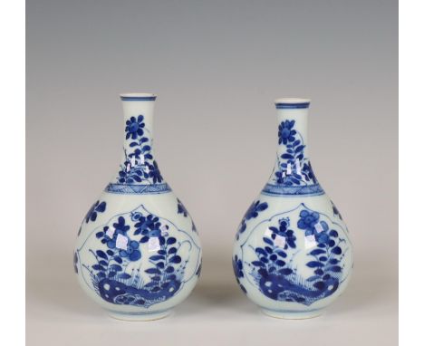 China, a pair of small blue and white porcelain bottle vases, Kangxi period (1662-1722), each with leaf-shaped panels enclosi