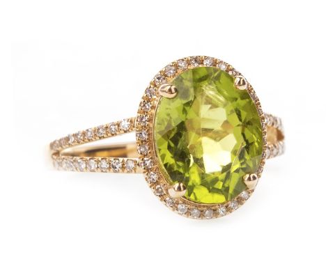 PERIDOT AND DIAMOND RING, the central oval peridot 11x7mm, within a halo of round brilliant cut diamonds, on bifurcated diamo