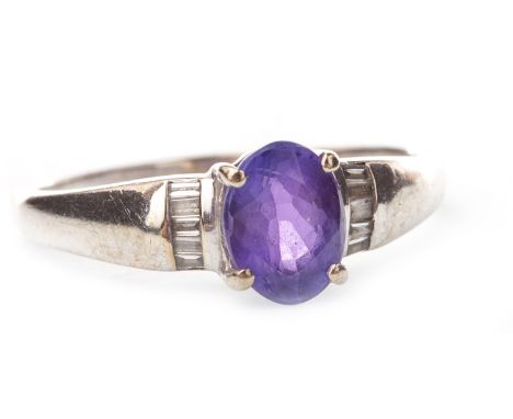 PURPLE GEM AND DIAMOND RING, the central oval purple gem 8x6mm, flanked by baguette cut diamonds to each shoulder, the stones