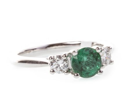 EMERALD AND DIAMOND RING, set with a central round faceted emerald 5.8mm diameter and flanked by two round brilliant cut diam