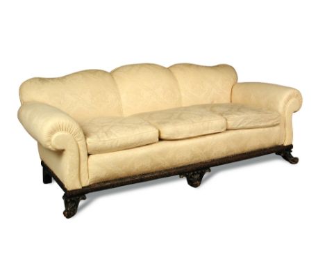 A large George II style sofa, 20th century,  with shaped back and loose cushions, upholstered in a yellow damask fabric, carv