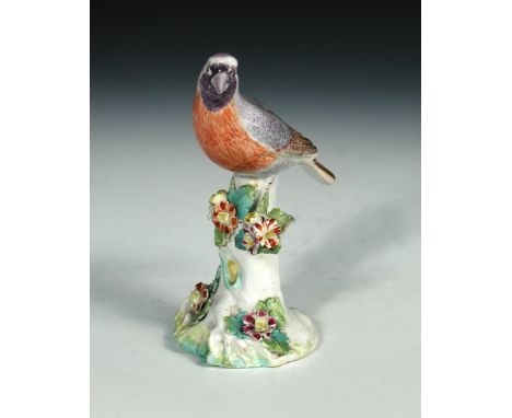 An 18th century Derby patch mark figure of a bird, naturalistically coloured and perched on a floral encrusted branch 14cm (5