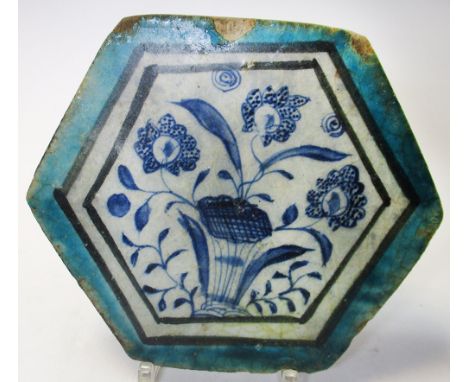 A 15th century Islamic Syrian Mamluk tile, of hexagonal form, the centre painted with flowers, with a black banded and turquo
