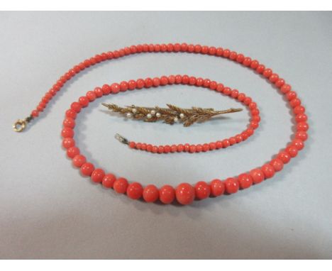 A coral bead necklace and a seed pearl heather frond brooch, the necklace of graduated 2.8 - 8.3mm coral beads, clasp stamped