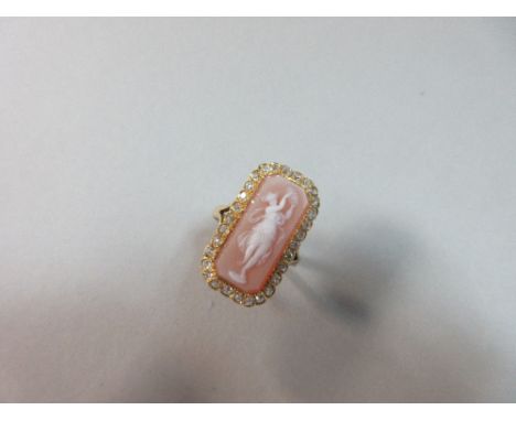 A hardstone cameo and diamond ring, the elongated octagonal plaque of light orange-brown and white agate carved to depict Ter