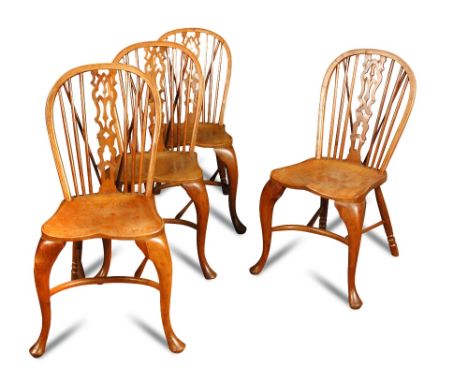 A set of four yew wood stick back chairs, late 19th century, with gothic carved and pierced splats, to elm saddle seats, on c