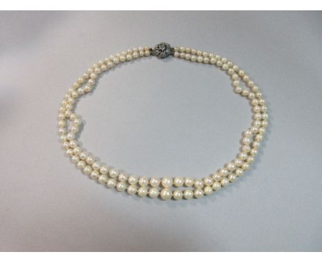 A two row pearl necklace, the 4.5-8.2mm graduated pearls individually knotted to a circular pierced flowerhead clasp, length 
