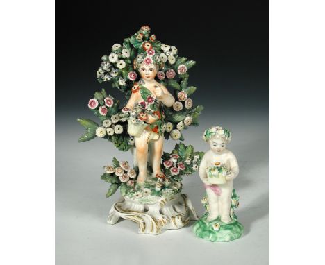 An 18th century Bow porcelain model of a putto, standing in front of boccage, on pierced scroll moulded base, painted anchor 