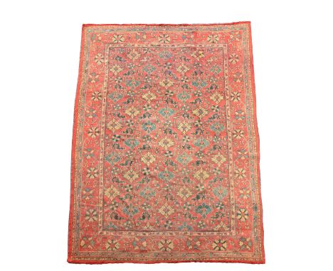 An Oushak red ground carpet, 365 x 250cm (142 x 98in)  Faded with small holes and some end loss, but good overall pile