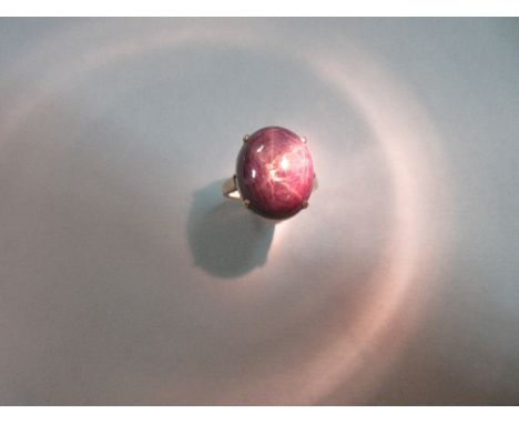 A star ruby ring, the opaque oval cabochon claret coloured ruby showing marked straight hexagonal banding and good asterism w