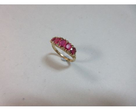 A five stone ruby ring with diamond highlights, the graduated oval cut rubies close set with rose cut diamonds in the interst