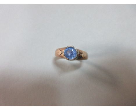 A single stone light blue spinel ring, the round cut spinel claw set above a collet to pierced tapered shoulders and a plain 