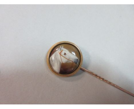 An enamel painted stick pin of a horse's head by William Bishop Ford, the grey horse with bridle, finely painted on a domed c
