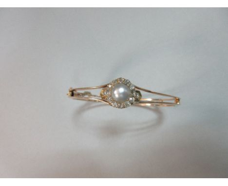 A pearl and diamond hinged bangle, the bangle designed as two knife-edge bars joined at intervals by short cross bars and fla