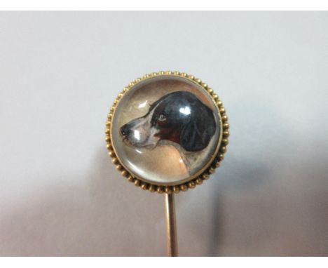 A reverse carved and painted crystal stick pin depicting a pointer, the circular crystal finely painted with the head of a wh