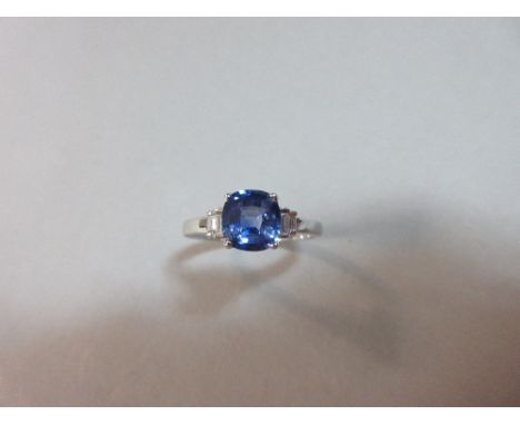 A light blue sapphire and diamond ring set in 18ct white gold, the cushion cut mid to light blue sapphire four claw set betwe
