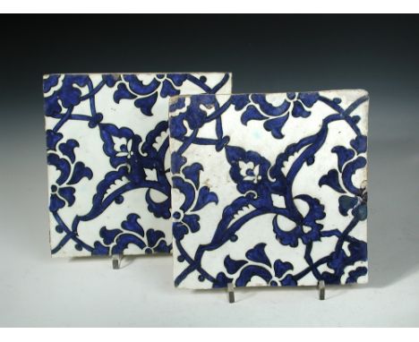 Two mid 16th century Iznik 'Dome of the Rock' tiles, each painted in blue on the diagonal with wing shaped leaves flanking bu