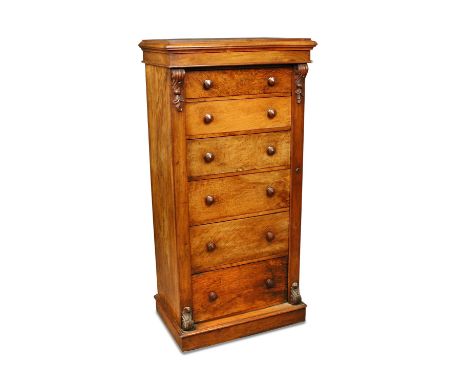 A William IV walnut Wellington chest, of six graduated drawers with locking bracket and applied leaf carved brackets, on a pl