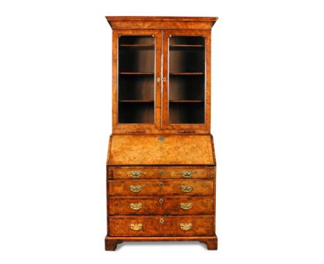 A George I walnut bureau bookcase, feather banded border inlaid decoration, with glazed doors and candle slides above a fitte