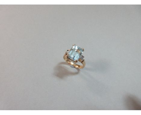 An aquamarine and diamond ring, the step cut emerald four claw set between single cut diamonds in square fields to a plain sh