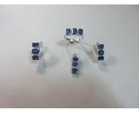 A sapphire and diamond suite of ring, earrings and pendant, each piece composed of a line of three cut-corner rectangular ste