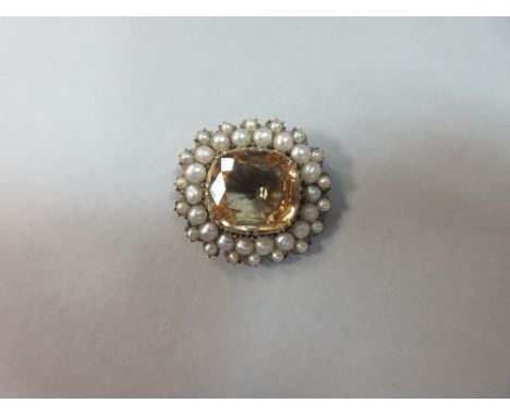 A Victorian topaz and seed pearl lace pin, with a cushion cut pale apricot coloured topaz in a border of 2.5mm seed pearls to