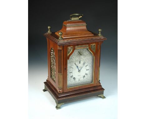 An Edwardian mahogany bracket clock, the traditional design case with brass stop fluted canted corners, foliate scroll engrav