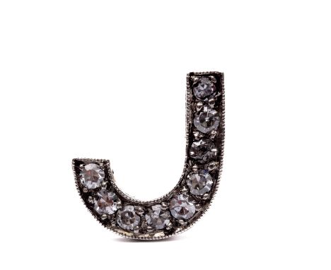 14 kt. Witgouden pin broche, letter J.  Bezet met achtkant geslepen diamant, ca. 0.15 ct. Pin onedel. bruto 2,2 gr., h. 10.5 