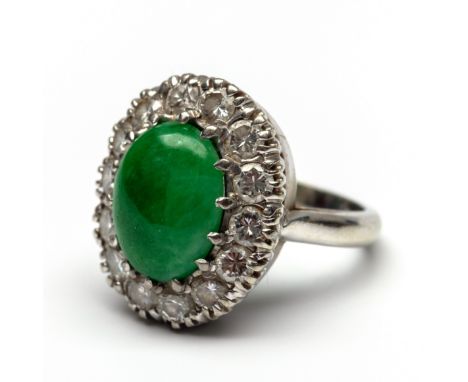 18 kt. witgouden ring, centraal gezet met een ovale cabochon geslepen jade in een entourage van briljant geslepen diamant, to