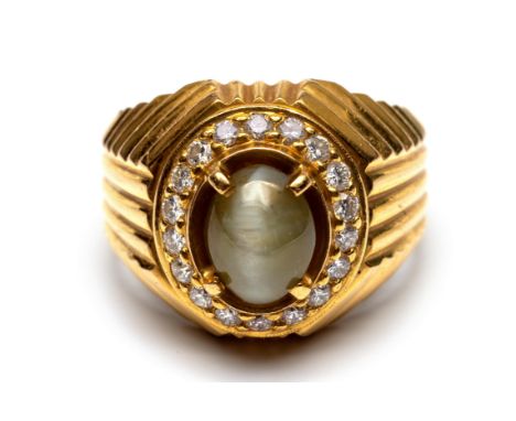 18 kt. Gouden ring, centraal bezet met een cabochon geslepen chrysoberyl kattenoog, in een entourage van briljant geslepen di