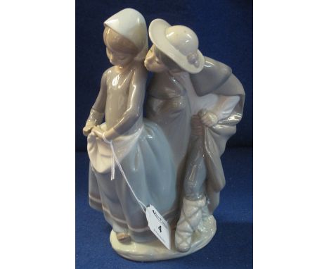 Lladro porcelain figure group of a young couple, he attempting a coy kiss, underglaze blue mark to base.
