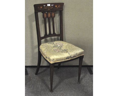 An early 20th Century dining chair, with in laid mother of pearl and wooden details in the form of flowers, with curved suppo