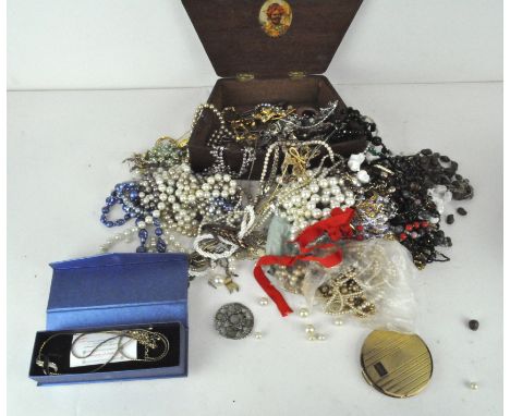 A large group of costume jewellery including necklaces, brooches, loose beads, a vintage compact, a shell-decorated jewellery