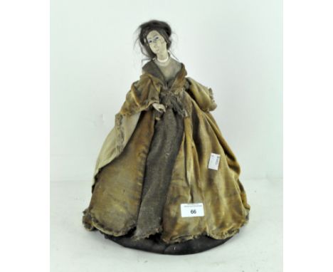 A vintage tea cosy, modelled  as a woman in 18th century style velvet gown, with painted plaster head, 37 cm high 