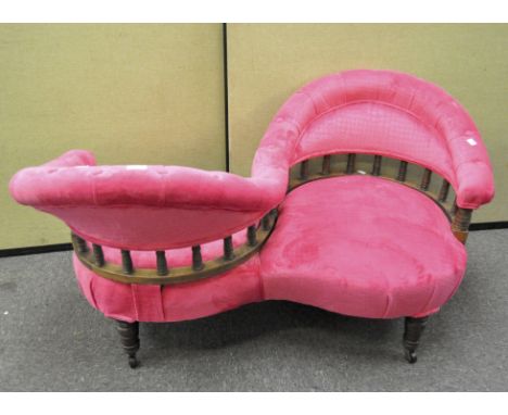 A Victorian conversation settee, with two seats upholstered in bright pink velvet, with button back top rails, on turned legs