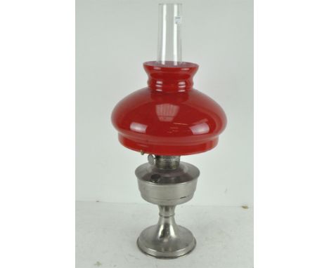 A vintage Super Aladdin oil lamp with original red and white glass shade and clear funnel